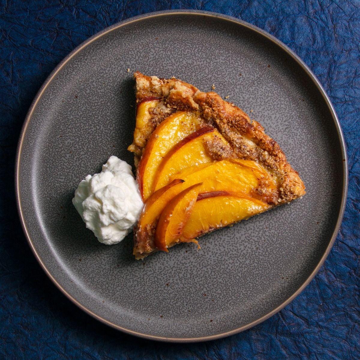 Slice of Peach Galette with whipped cream